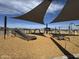 View of playground featuring climbing equipment and lounge chairs shaded by canopies in a wood chip base at 15510 W Deanne Dr, Waddell, AZ 85355