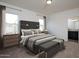 Well-lit bedroom with a stylish bed, neutral decor, and an en-suite bathroom at 15644 W Deanne Dr, Waddell, AZ 85355