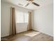 Light-filled bedroom with wood-look floors, neutral curtains, and a ceiling fan at 16017 N 19Th Dr, Phoenix, AZ 85023