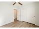 Bedroom features wood floors, a ceiling fan, a closet with sliding doors, and white walls at 16017 N 19Th Dr, Phoenix, AZ 85023