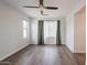 Sunlit bedroom with wood floors, large windows, and modern ceiling fan at 16017 N 19Th Dr, Phoenix, AZ 85023