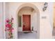 Covered front entry featuring an arched entryway, red door, desert plants, and house number at 16017 N 19Th Dr, Phoenix, AZ 85023