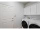 Convenient laundry room features modern washer and dryer, white cabinets for storage, and door to outside at 16017 N 19Th Dr, Phoenix, AZ 85023