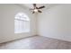 Living room features high ceilings, a ceiling fan, tile floors, and a large arched window at 16017 N 19Th Dr, Phoenix, AZ 85023