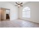 Spacious living area featuring tile floors, ceiling fan, a staircase, and a large arched window at 16017 N 19Th Dr, Phoenix, AZ 85023