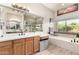 Bright bathroom with double vanity, quartz countertop, tub, and walk-in shower at 16201 S 29Th Ave, Phoenix, AZ 85045