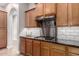 Close-up of the kitchen featuring wood cabinets, granite countertops, stainless hood and white subway tile backsplash at 16201 S 29Th Ave, Phoenix, AZ 85045