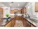 Spacious kitchen featuring wood floors, wooden cabinetry, granite countertops, and stainless steel appliances at 16201 S 29Th Ave, Phoenix, AZ 85045