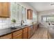 Spacious kitchen with wood cabinets, granite countertops, stainless appliances, and view to an open living space at 16201 S 29Th Ave, Phoenix, AZ 85045