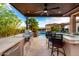 Outdoor kitchen featuring modern appliances, bar seating, with a pool and desert landscaping at 16201 S 29Th Ave, Phoenix, AZ 85045