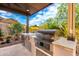 Outdoor kitchen area with stainless steel appliances, built-in grill, and desert views at 16201 S 29Th Ave, Phoenix, AZ 85045