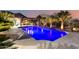 Beautiful backyard pool with water features, mature landscaping, and outdoor kitchen area at twilight at 16201 S 29Th Ave, Phoenix, AZ 85045