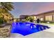 Stunning pool with lights set in a private backyard and views of the home's exterior and manicured landscaping at 16201 S 29Th Ave, Phoenix, AZ 85045