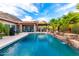 Beautiful backyard oasis with a sparkling pool, rock waterfall, and outdoor kitchen area for hosting gatherings at 16201 S 29Th Ave, Phoenix, AZ 85045