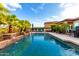 Lush backyard showcasing a beautiful pool with a rock waterfall, palm trees, and plenty of space for outdoor enjoyment at 16201 S 29Th Ave, Phoenix, AZ 85045