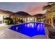 Expansive backyard features a dazzling pool, covered patio, outdoor seating, and stunning mountain views at dusk at 16201 S 29Th Ave, Phoenix, AZ 85045