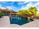 Inviting backyard featuring a sparkling pool, stone waterfall, and lush landscaping, providing a serene escape at 16201 S 29Th Ave, Phoenix, AZ 85045