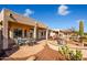 Picturesque backyard featuring a patio area with table and chairs, plus a landscaped seating area overlooking the golf course at 20455 N Lemon Drop Dr, Maricopa, AZ 85138