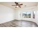 Bright bedroom with wood-look floors, ceiling fan, and large windows with views at 20455 N Lemon Drop Dr, Maricopa, AZ 85138