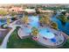 Aerial view of large community pool with palm trees, lounge chairs, and umbrellas, perfect for relaxation at 20455 N Lemon Drop Dr, Maricopa, AZ 85138