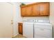 Laundry room featuring washer and dryer and wood cabinets at 20455 N Lemon Drop Dr, Maricopa, AZ 85138