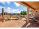 Inviting covered patio featuring brick pavers, a built-in bench, and a peaceful outdoor seating area at 20455 N Lemon Drop Dr, Maricopa, AZ 85138