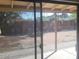 View of a backyard with pavers and a corrugated metal fence seen through a glass door at 207 E Papago Dr, Tempe, AZ 85288