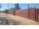 Long, ornate metal gate in a woven pattern in front of a sand-covered yard at 207 E Papago Dr, Tempe, AZ 85288