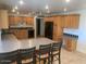 A spacious kitchen features wooden cabinets, a tiled floor, and a long center island with bar stool seating at 207 E Papago Dr, Tempe, AZ 85288