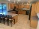 A spacious kitchen features wooden cabinets, a tiled floor, and a long center island with bar stool seating at 207 E Papago Dr, Tempe, AZ 85288