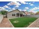 Attractive backyard showcasing synthetic grass, a covered patio, and a well-maintained block fence at 20866 W Hamilton St, Buckeye, AZ 85396
