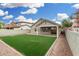 Charming backyard with green synthetic grass, covered patio and block fence offering privacy at 20866 W Hamilton St, Buckeye, AZ 85396