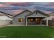 Twilight view of the back of a house, showing the covered patio and fenced yard at 20866 W Hamilton St, Buckeye, AZ 85396