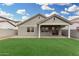 Well-maintained backyard featuring a covered patio, synthetic grass, and a secure block fence at 20866 W Hamilton St, Buckeye, AZ 85396