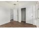 Bedroom with wood-style tile floor, sliding door closet, and two doorways at 20866 W Hamilton St, Buckeye, AZ 85396
