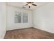 An empty bedroom with a ceiling fan and two windows that let in natural light at 20866 W Hamilton St, Buckeye, AZ 85396