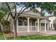 Charming home with a cozy front porch, manicured lawn, and mature trees, enhancing its curb appeal at 20866 W Hamilton St, Buckeye, AZ 85396