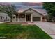 Quaint single-story home featuring a welcoming front porch and green lawn at dusk at 20866 W Hamilton St, Buckeye, AZ 85396