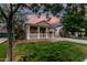 Charming single-story home with a welcoming front porch and lush green lawn at dusk at 20866 W Hamilton St, Buckeye, AZ 85396