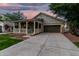 Welcoming single-story home boasting a charming front porch and spacious driveway at dusk at 20866 W Hamilton St, Buckeye, AZ 85396