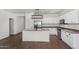 Modern kitchen featuring white cabinets, stainless steel appliances, and a functional island with a sink at 20866 W Hamilton St, Buckeye, AZ 85396