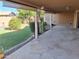 Covered stone patio featuring a manicured backyard with green grass and mature trees, perfect for outdoor relaxation at 2434 S Colleen --, Mesa, AZ 85210