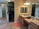 Bathroom featuring dual sinks, granite counters, a large mirror, and walk-in closet at 2585 E Carob Dr, Gilbert, AZ 85298