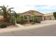 Single-story home with a desert landscaped yard, gated front porch, and two car garage at 2585 E Carob Dr, Gilbert, AZ 85298