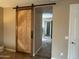 Hallway featuring a barn door entrance to the bathroom with carpet flooring at 2585 E Carob Dr, Gilbert, AZ 85298