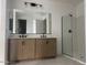 Modern bathroom with a double sink vanity and glass enclosed shower at 26119 N 23Rd Ave, Phoenix, AZ 85085