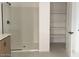 Bright bathroom with an open shelving unit and glass shower at 26119 N 23Rd Ave, Phoenix, AZ 85085