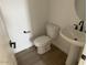 Powder room featuring a pedestal sink, toilet, and modern fixtures at 26119 N 23Rd Ave, Phoenix, AZ 85085