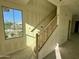 A bright staircase with natural wood handrail with view of neighborhood through a window at 26119 N 23Rd Ave, Phoenix, AZ 85085