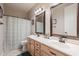 Bathroom featuring double sinks, wood cabinets, framed mirrors, and a shower with a curtain at 3053 S Canfield --, Mesa, AZ 85212